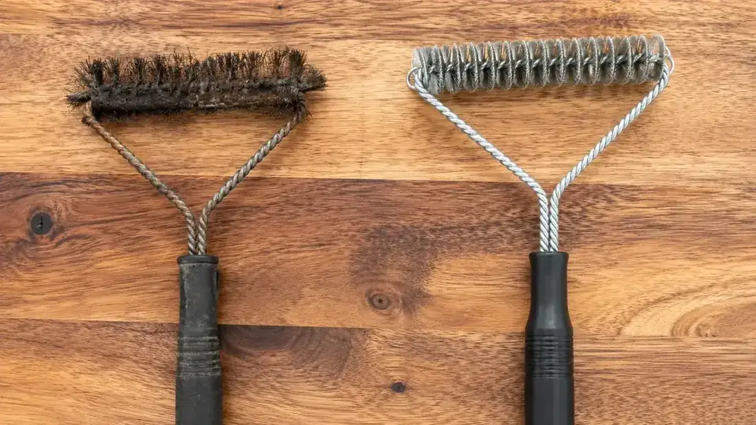 Two grill brush heads side by side: one traditional bristle brush showing frayed loose wires, one woven-coil bristle-free brush looking intact
